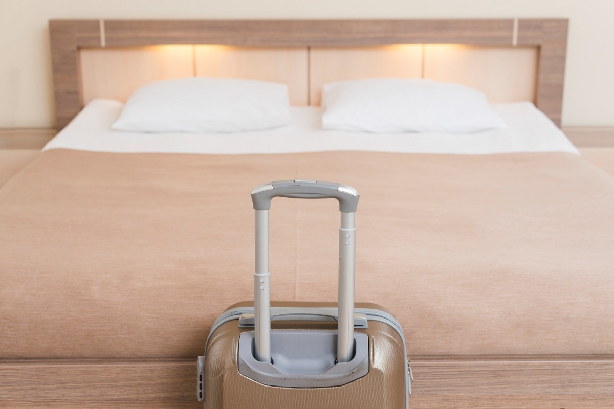 Quarto de Airbnb com mala de frente para cama