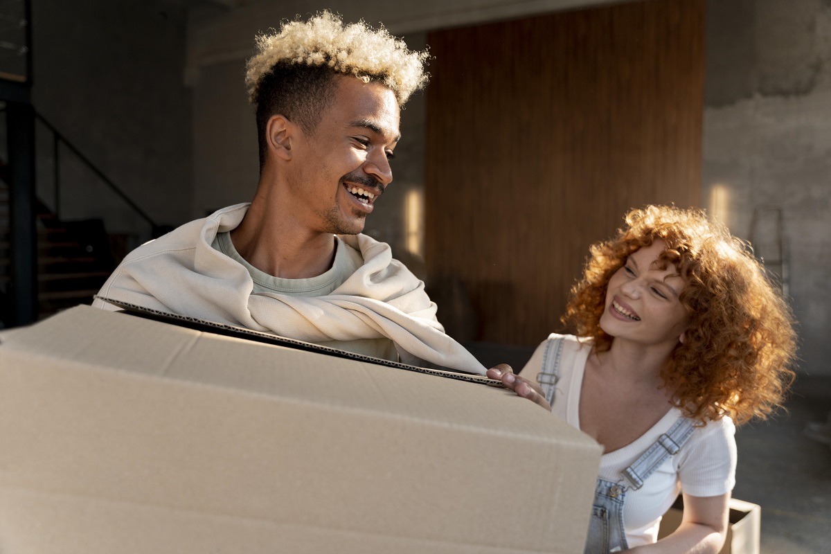 Casal com caixas de papelão para mudança